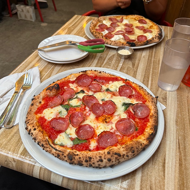 Two Neapolitan-style pepperoni pizzas on a restaurant table